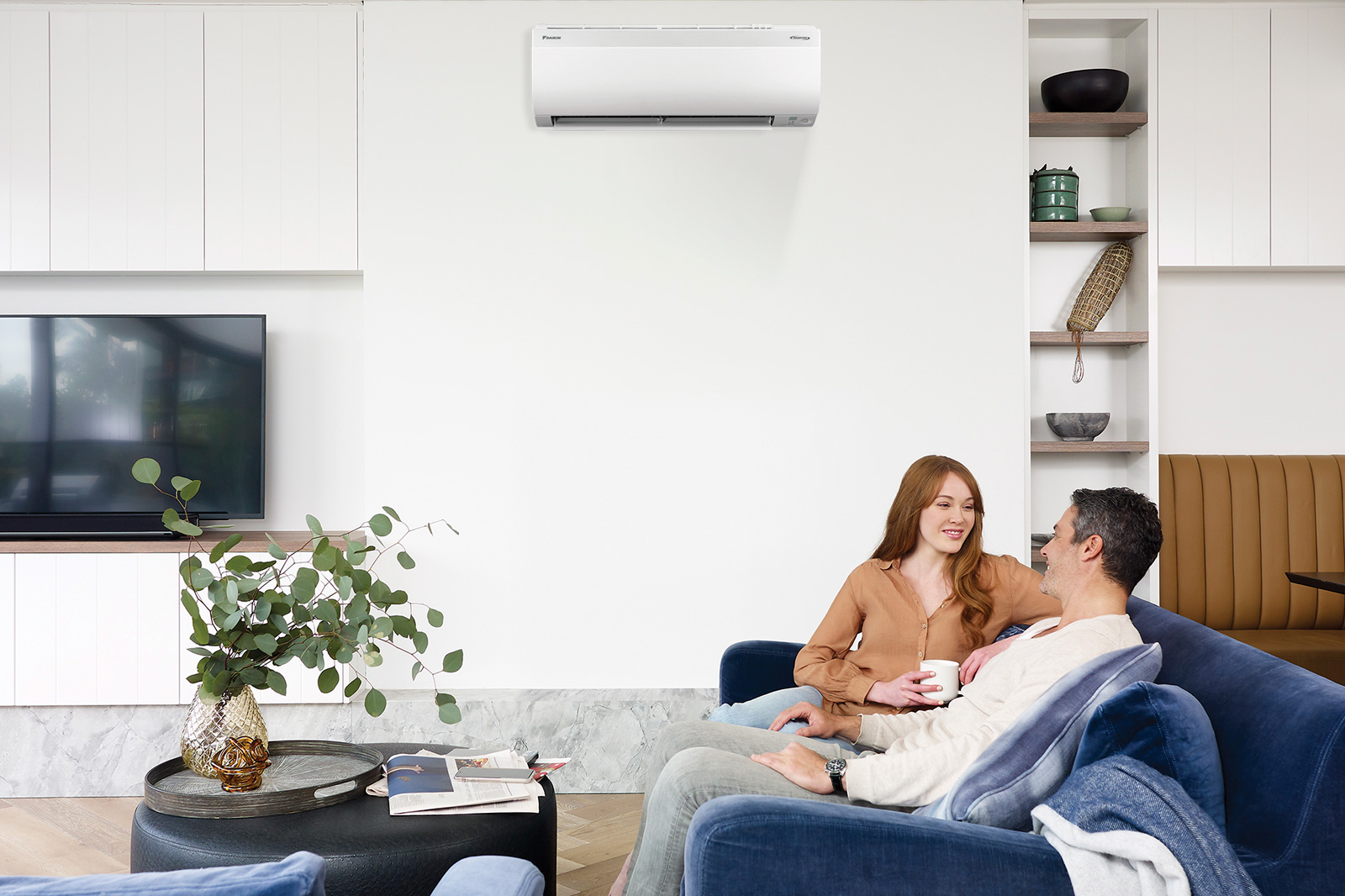 couple on couch under ductless ac